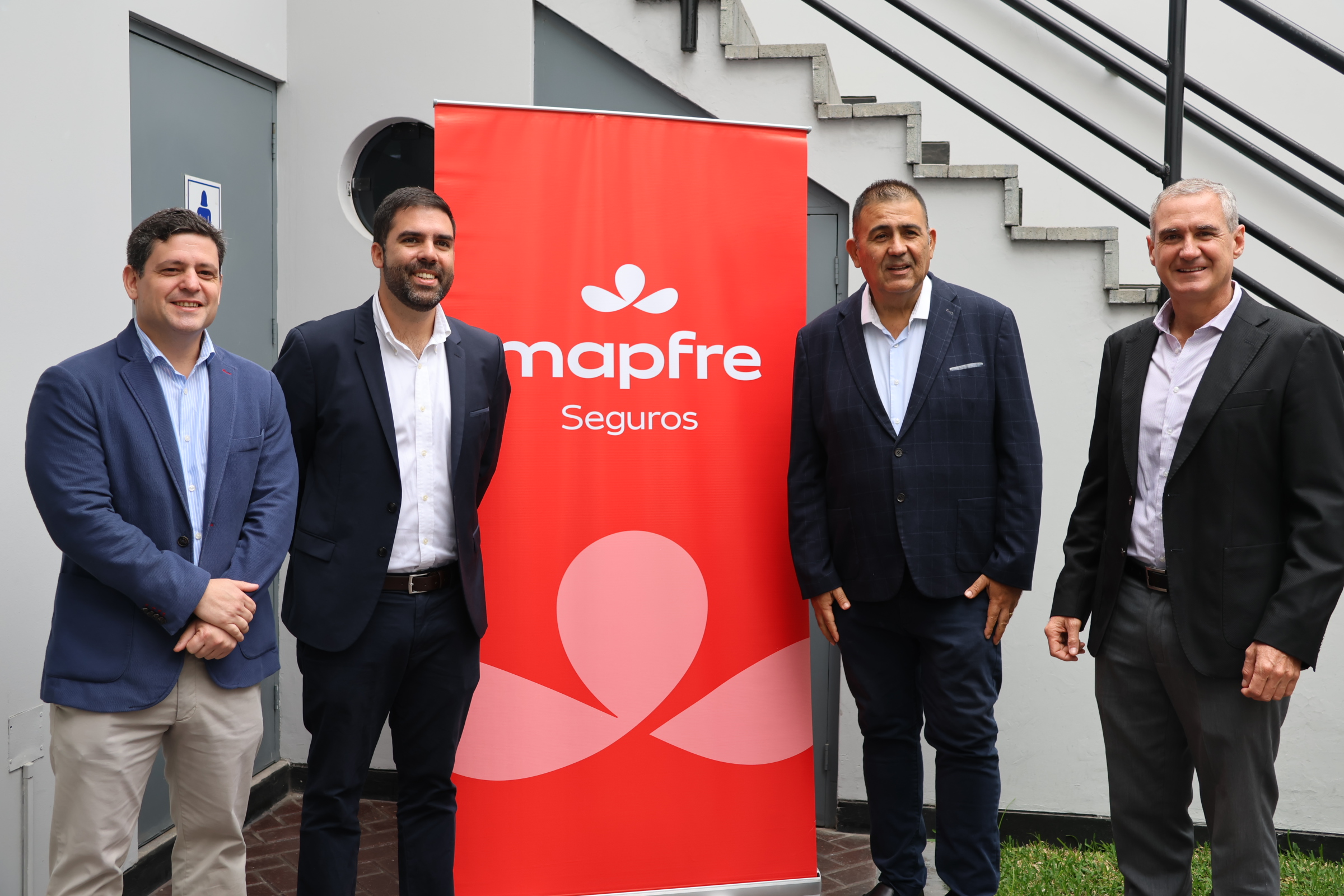 Representantes de MAPFRE y participantes junto a la identificación institucional de la aseguradora